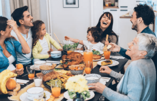 family laughing at a dinner table - how to discuss the elections respectfully at home